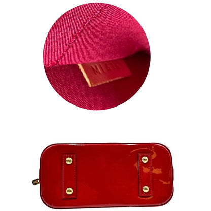 base Borsa Louis Vuitton Alma BB in pelle vernis rossa con trama monogram empreinte e parti metalliche dorate. Munita di doppi manici stondati e tracolla amovibile, dotata di clochette porta chiavi. Completa di scatola, lucchetto e chiavi, di lusso, originale, ottime condizioni.