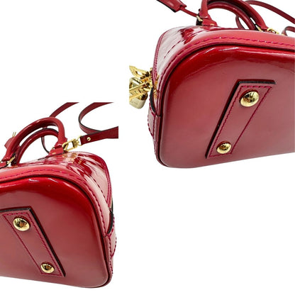 angoli Borsa Louis Vuitton Alma BB in pelle vernis rossa con trama monogram empreinte e parti metalliche dorate. Munita di doppi manici stondati e tracolla amovibile, dotata di clochette porta chiavi. Completa di scatola, lucchetto e chiavi, di lusso, originale, ottime condizioni. 