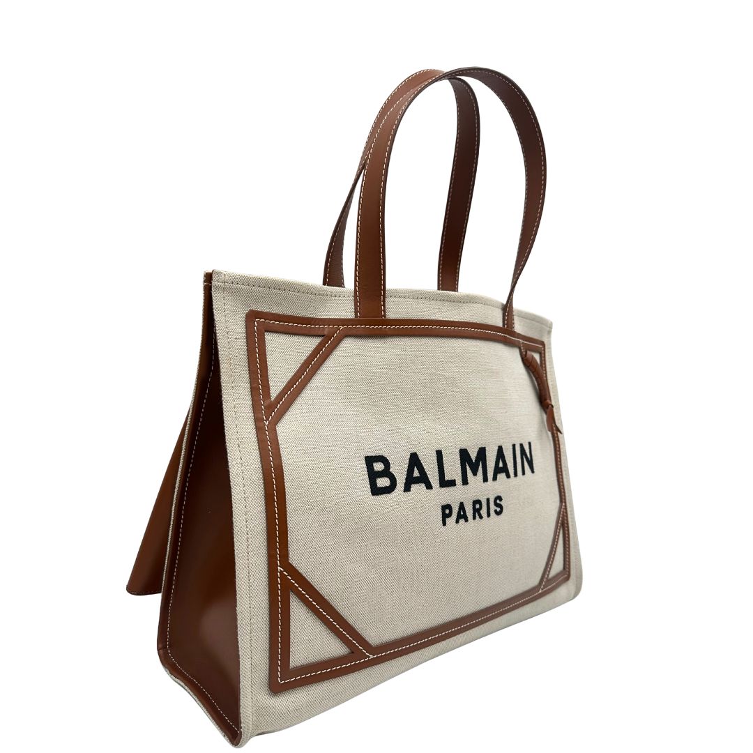 lato Borsa Balmain in tessuto color sabbia rifinita con parti in pelle marroni; munita di doppi manici e una pochette estraibile 