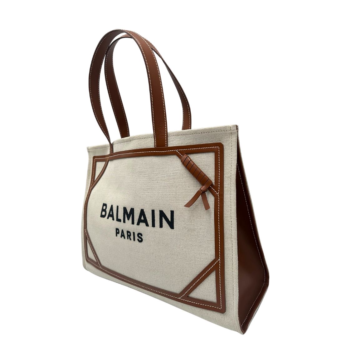 lato Borsa Balmain in tessuto color sabbia rifinita con parti in pelle marroni; munita di doppi manici e una pochette estraibile 