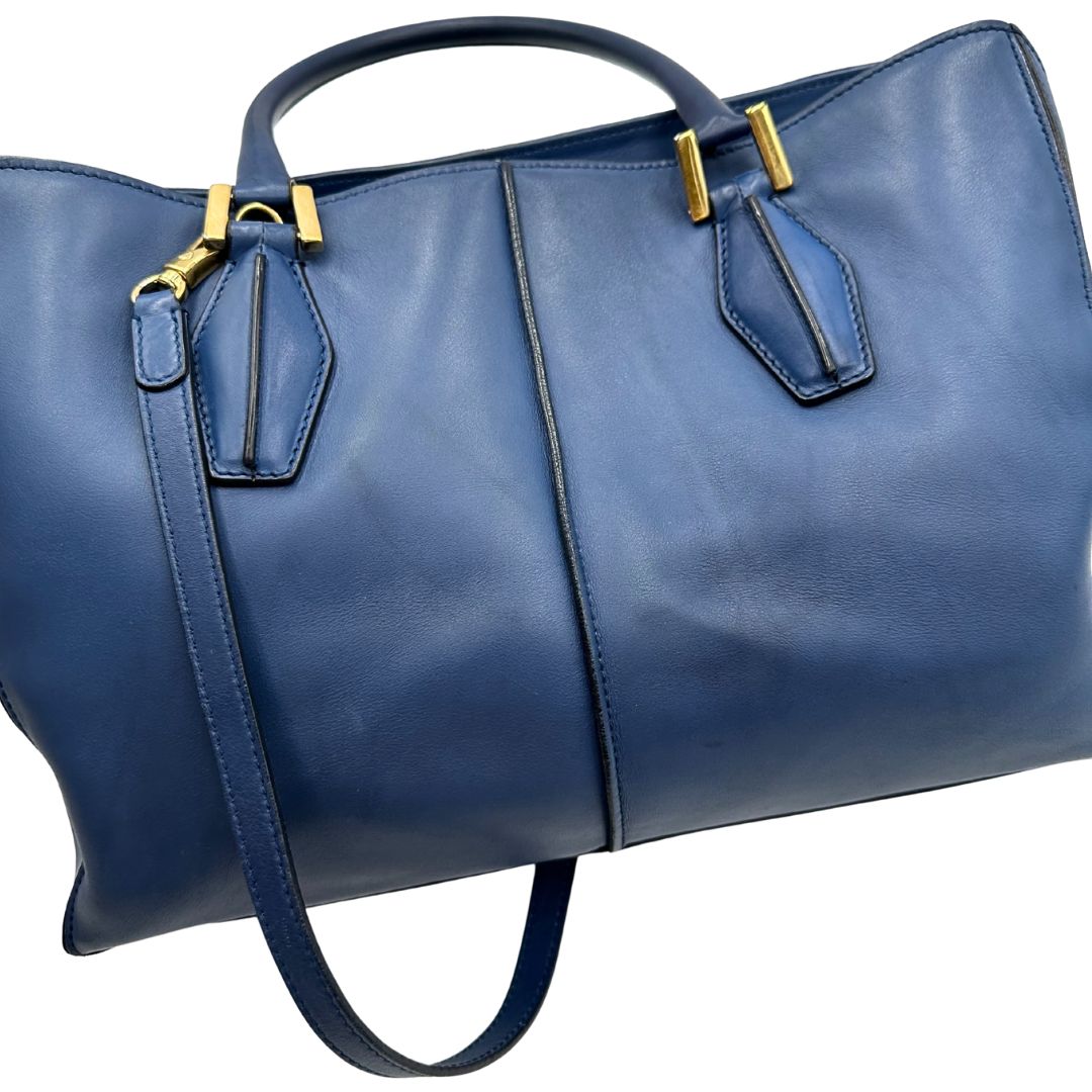 Bauletto Tod's in pelle blu con parti metalliche dorate; munita di doppi manici stondati e una tracolla amovibile e regolabile 