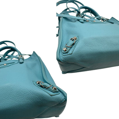 angoli  Borsa Balenciaga in pelle color turchese con parti metalliche argentate; munita di doppi manici stondati e una tracolla amovibile e regolabile. Completa di dustbag e cartellini, di lusso, originale. 