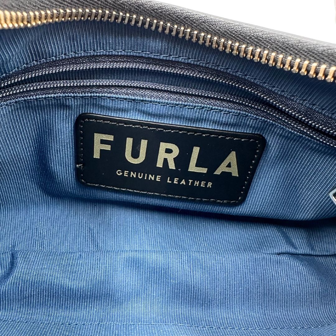 interno Borsa Furla in pelle nera con parti metalliche dorate; munita di un manico singolo, indossabile a spalla. Completa di dustbag  