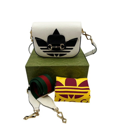 Borsa Gucci x Adidas in pelle martellata bianca con logo Adidas e parti metalliche dorate, munita di una tracolla Web verde e rossa. Completa di corredo, di lusso, originale.