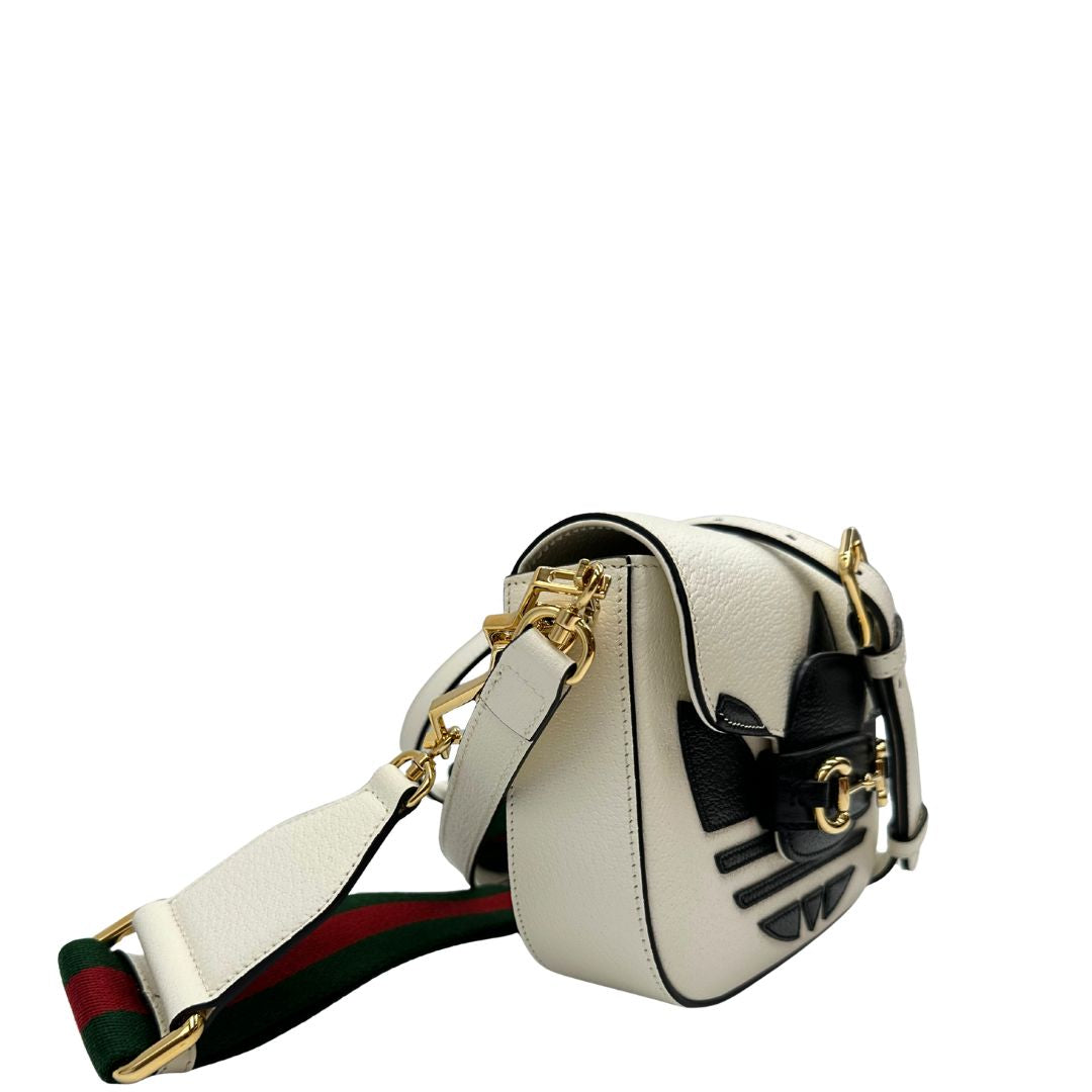 lato Borsa Gucci x Adidas in pelle martellata bianca con logo Adidas e parti metalliche dorate, munita di una tracolla Web verde e rossa. Completa di corredo, di lusso, originale. 