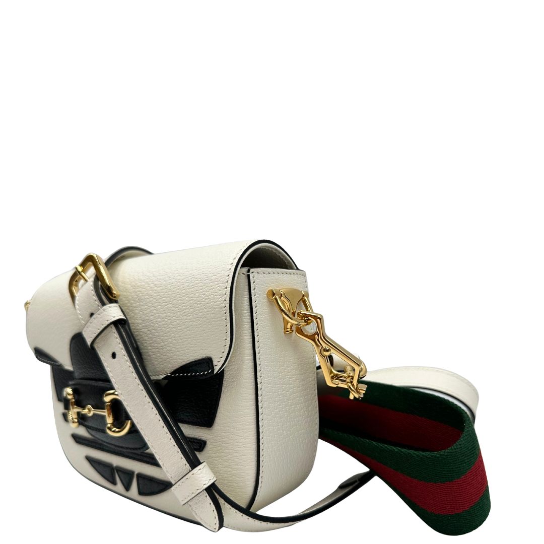 lato Borsa Gucci x Adidas in pelle martellata bianca con logo Adidas e parti metalliche dorate, munita di una tracolla Web verde e rossa. Completa di corredo, di lusso, originale. 