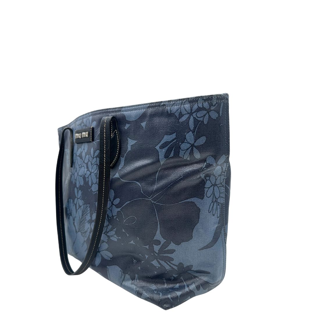 lato  Borsa Miu Miu in canvas sui toni del blu con trama floreale e parti metalliche argentate; munita di doppi manici. Completa di dustbag, di lusso, originale, usata. 