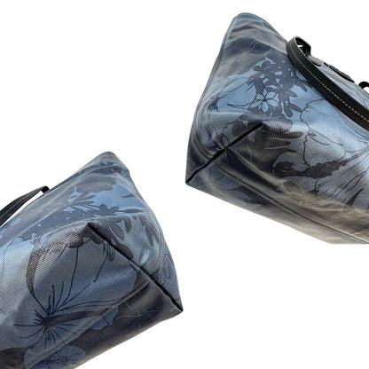 angoli  Borsa Miu Miu in canvas sui toni del blu con trama floreale e parti metalliche argentate; munita di doppi manici. Completa di dustbag, di lusso, originale, usata. 