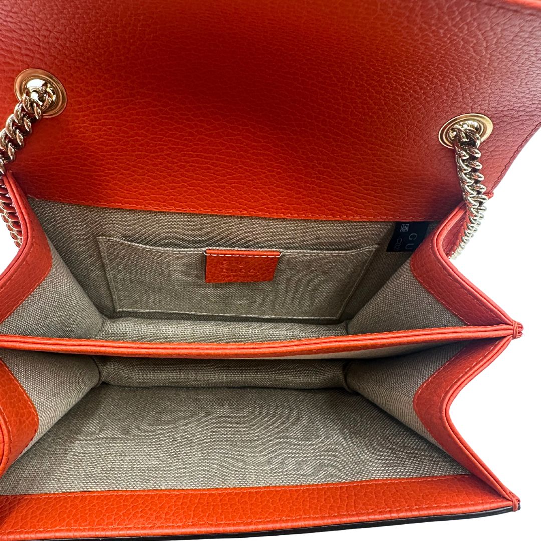 Interno Borsa Gucci Interlocking in pelle martellata arancione con parti metalliche dorate. Munita di una tracolla scorrevole in catena e spallaccio. Rifinita con chiusura doppie G incrociate. Completa di dustbag. Originale, usato, in condizioni ottime. 