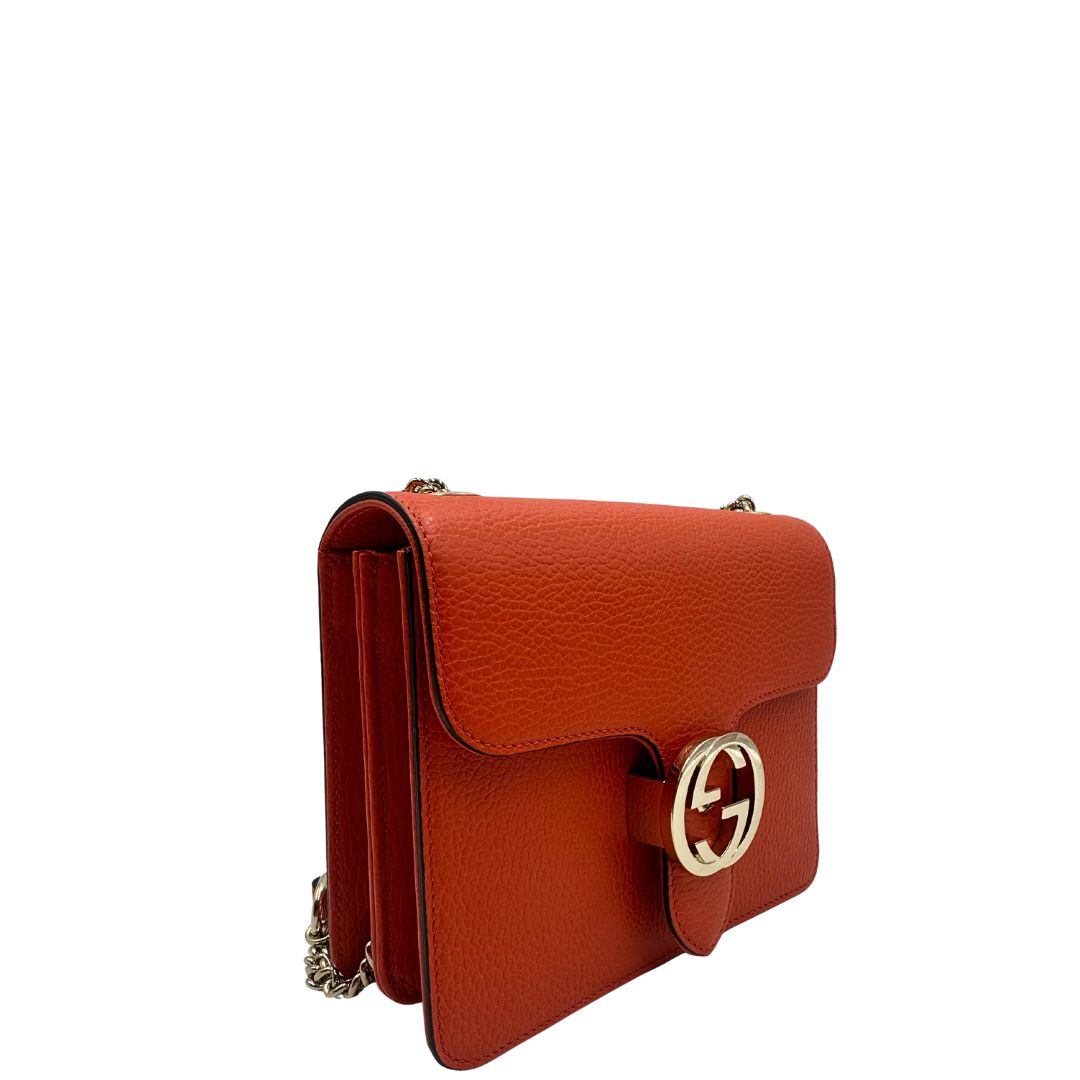 Laterale Borsa Gucci Interlocking in pelle martellata arancione con parti metalliche dorate. Munita di una tracolla scorrevole in catena e spallaccio. Rifinita con chiusura doppie G incrociate. Completa di dustbag. Originale, usato, in condizioni ottime. 
