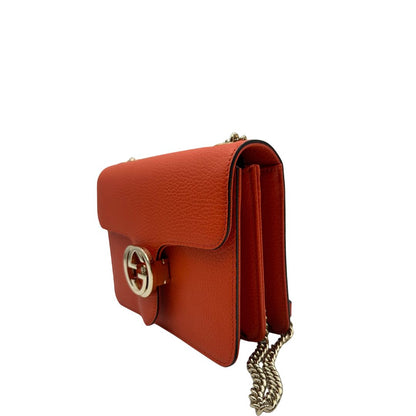 Laterale Borsa Gucci Interlocking in pelle martellata arancione con parti metalliche dorate. Munita di una tracolla scorrevole in catena e spallaccio. Rifinita con chiusura doppie G incrociate. Completa di dustbag. Originale, usato, in condizioni ottime. 