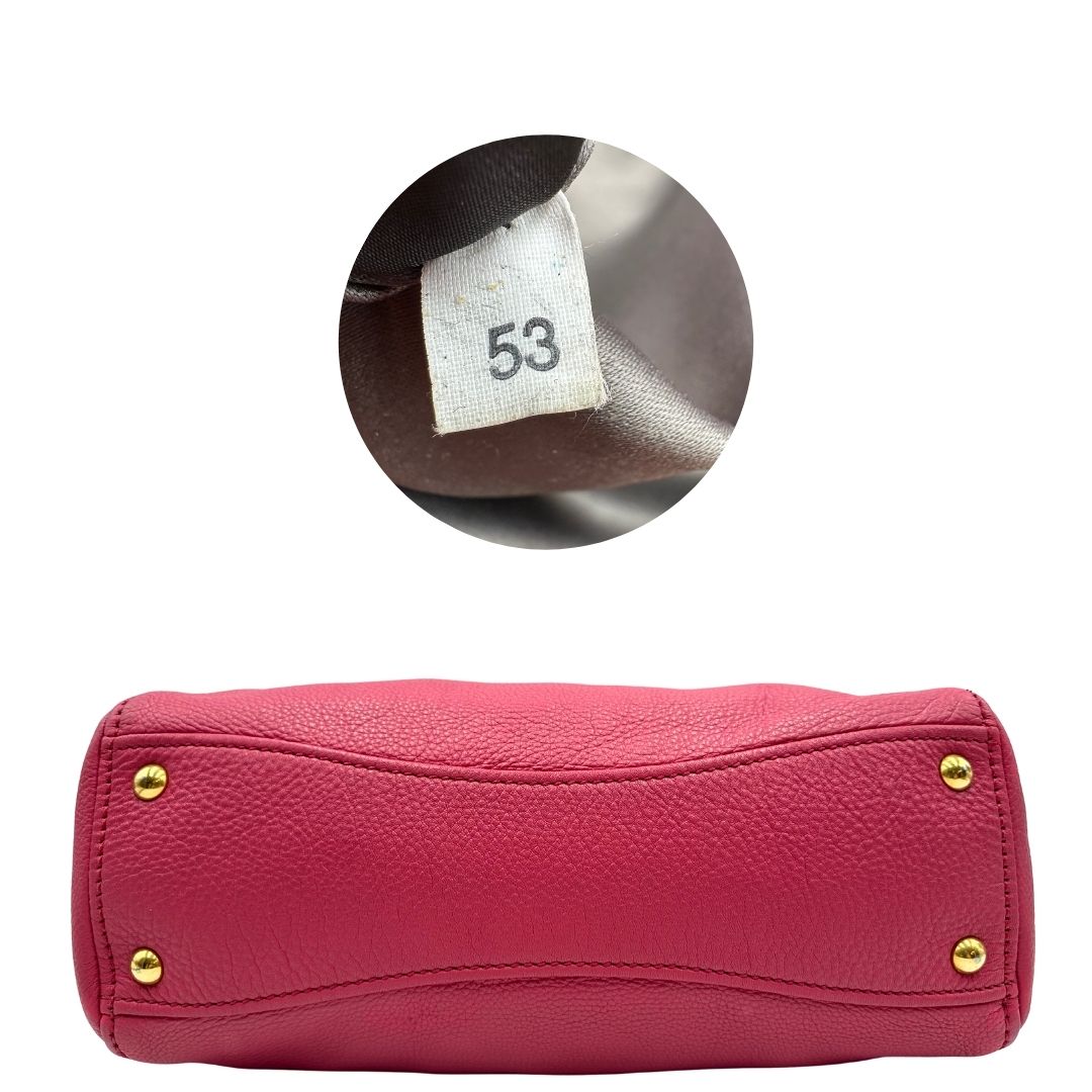 base Borsa Miu Miu in pelle martellata color rosa orchidea con parti metalliche dorate; munita di doppi manici e una tracolla tracolla amovibile e regolabile. Completa di dustbag, di lusso, originale, ottime condizioni. 