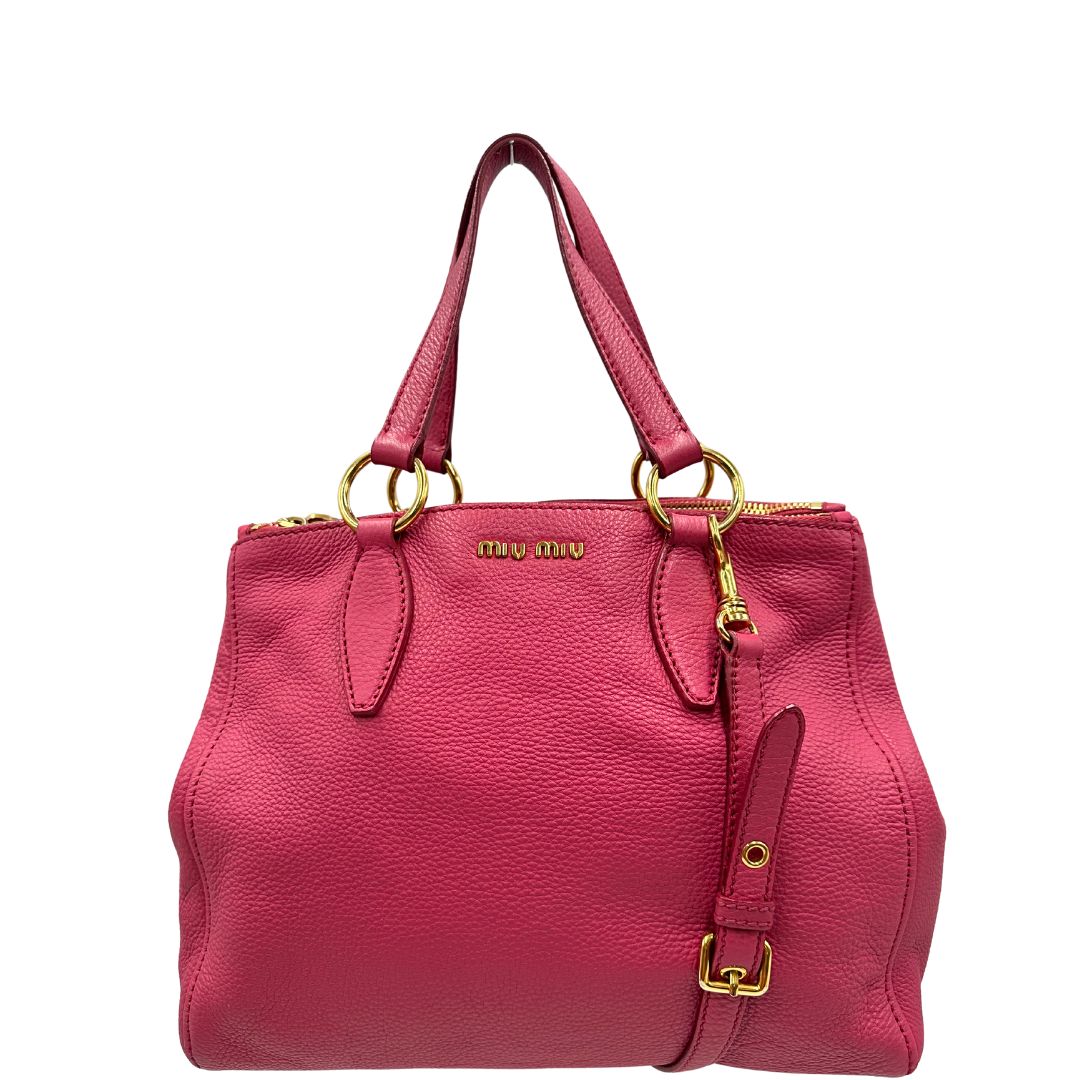 front Borsa Miu Miu in pelle martellata color rosa orchidea con parti metalliche dorate; munita di doppi manici e una tracolla tracolla amovibile e regolabile. Completa di dustbag, di lusso, originale, ottime condizioni.