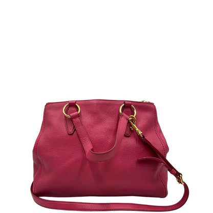 retro Borsa Miu Miu in pelle martellata color rosa orchidea con parti metalliche dorate; munita di doppi manici e una tracolla tracolla amovibile e regolabile. Completa di dustbag, di lusso, originale, ottime condizioni. 