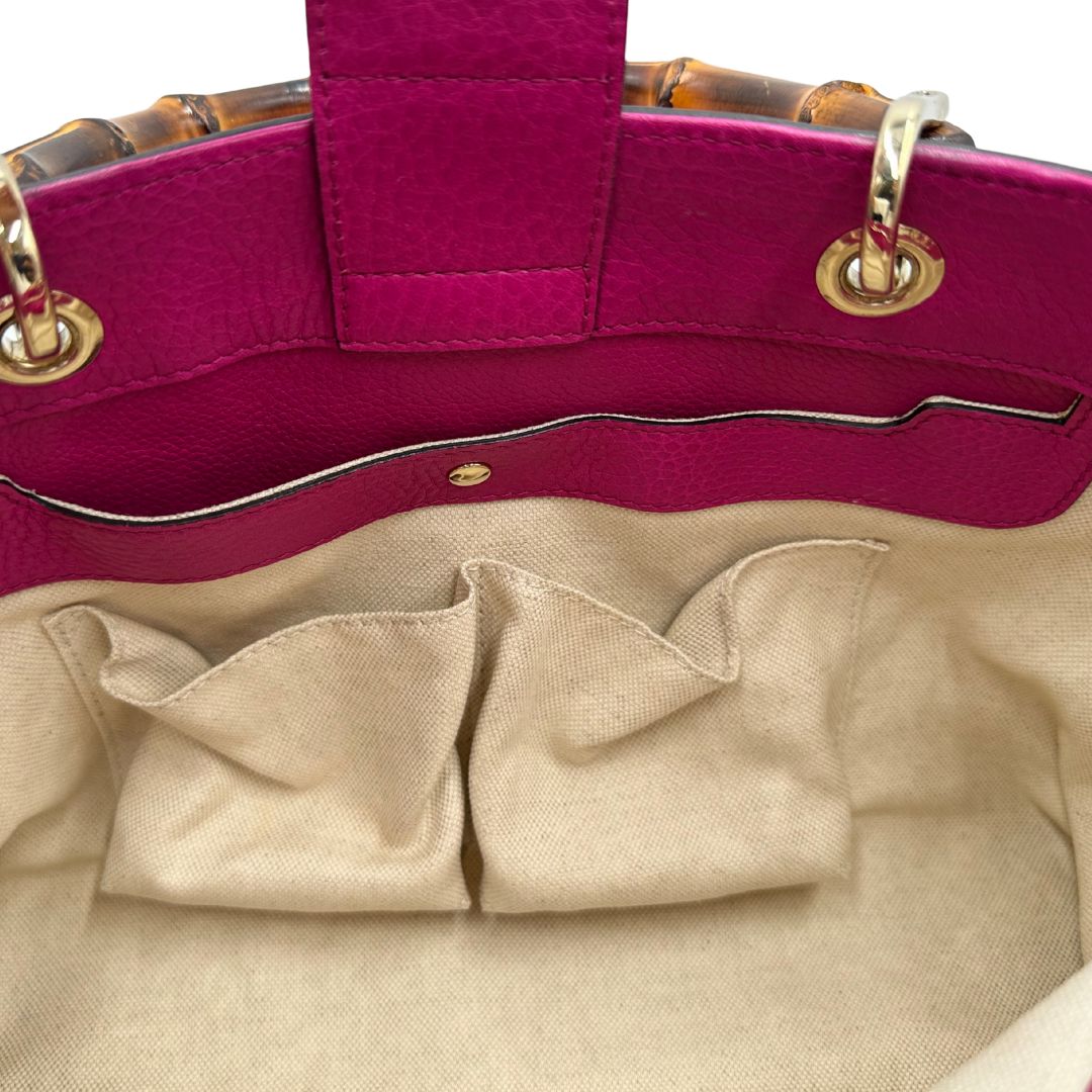 interno Borsa Gucci in pelle martellata fucsia con parti metalliche dorate; munita di doppi manici in bamboo e una tracolla amovibile e regolabile, di lusso, ottime condizioni, usata. 