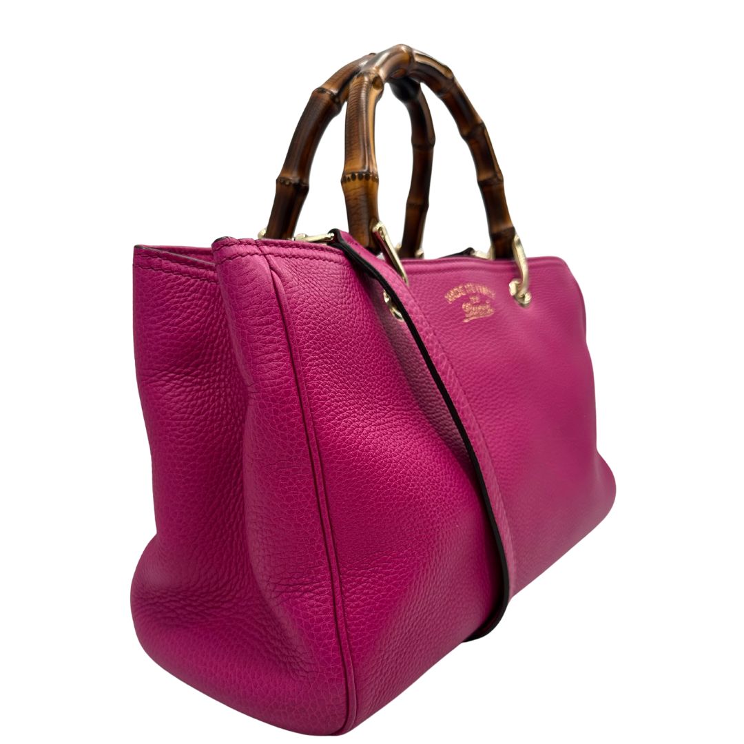 lato Borsa Gucci in pelle martellata fucsia con parti metalliche dorate; munita di doppi manici in bamboo e una tracolla amovibile e regolabile, di lusso, ottime condizioni, usata. 