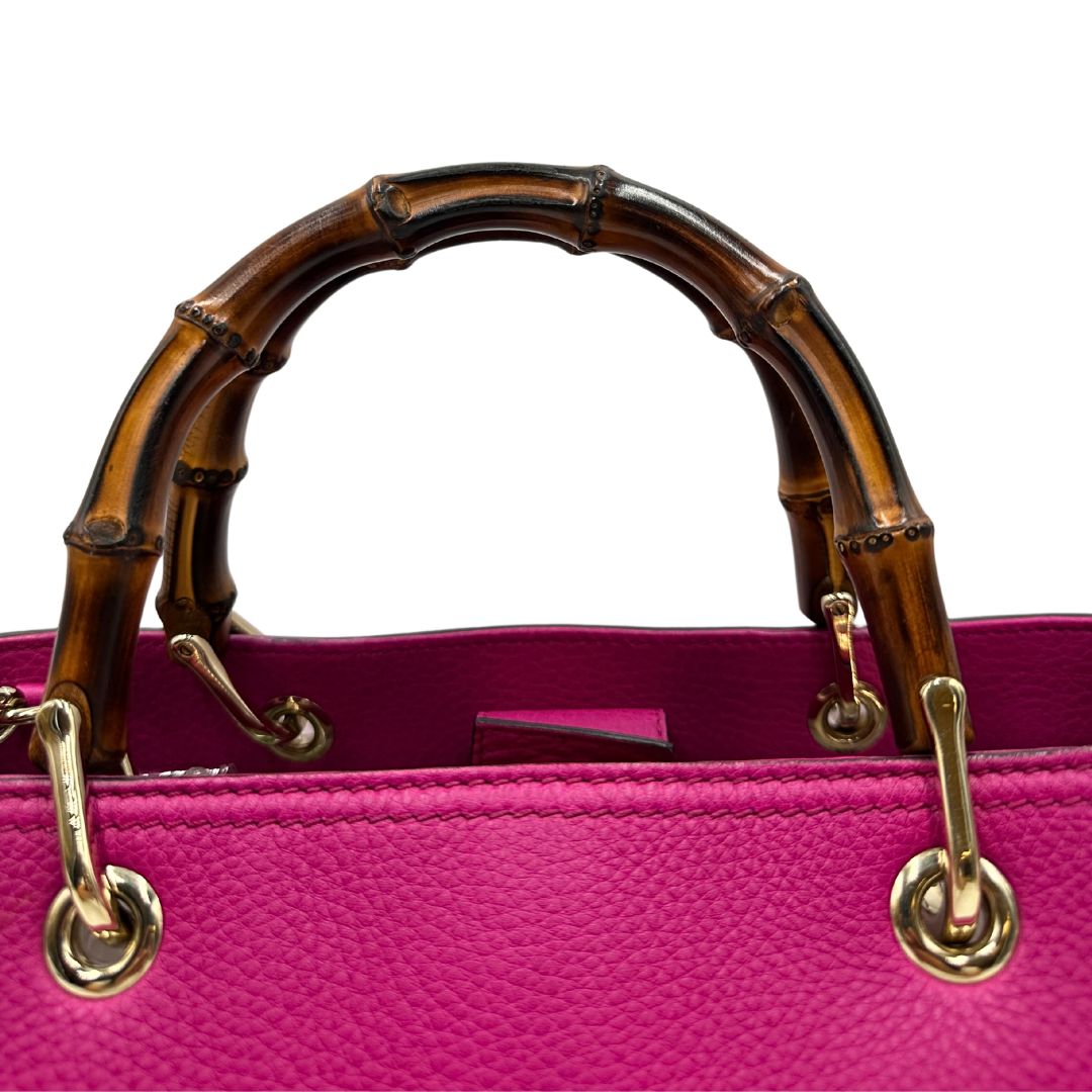 manici Borsa Gucci in pelle martellata fucsia con parti metalliche dorate; munita di doppi manici in bamboo e una tracolla amovibile e regolabile, di lusso, ottime condizioni, usata. 