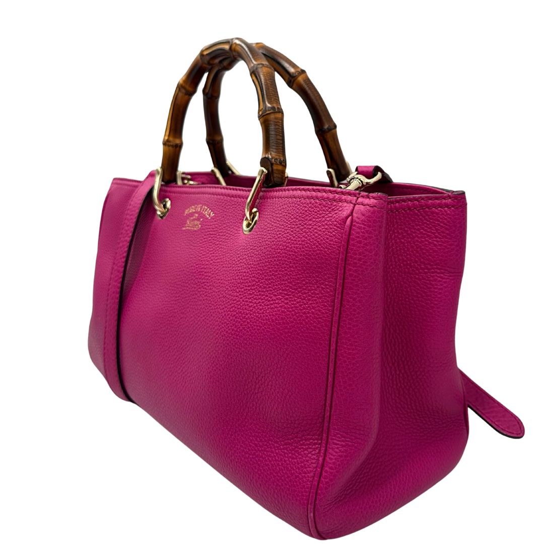 lato Borsa Gucci in pelle martellata fucsia con parti metalliche dorate; munita di doppi manici in bamboo e una tracolla amovibile e regolabile, di lusso, ottime condizioni, usata. 