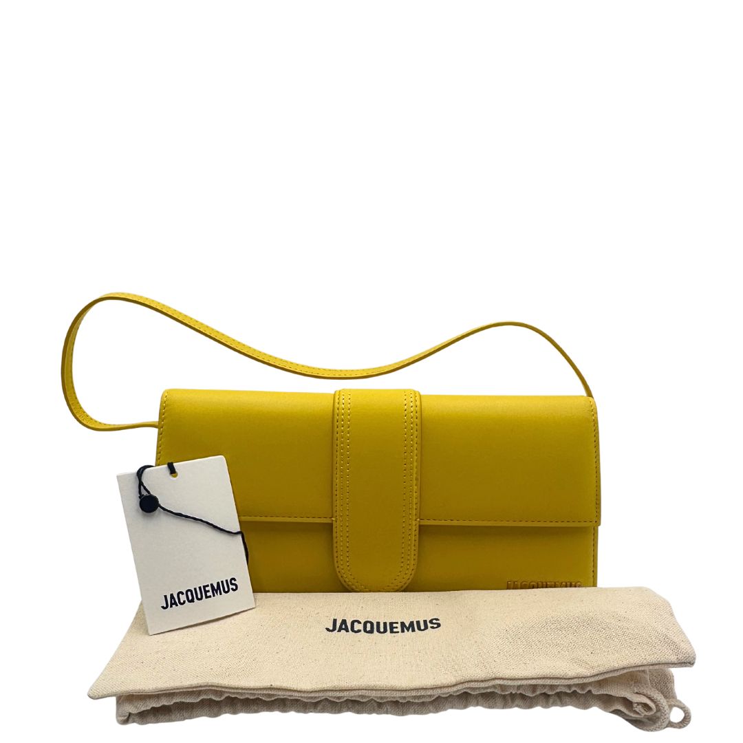 Borsa Jacquemus Le Bambino Long in pelle gialla con parti metalliche dorate; munita di un manico singolo. Completa di dustbag e cartellini, di lusso, originale, ottime condizioni.