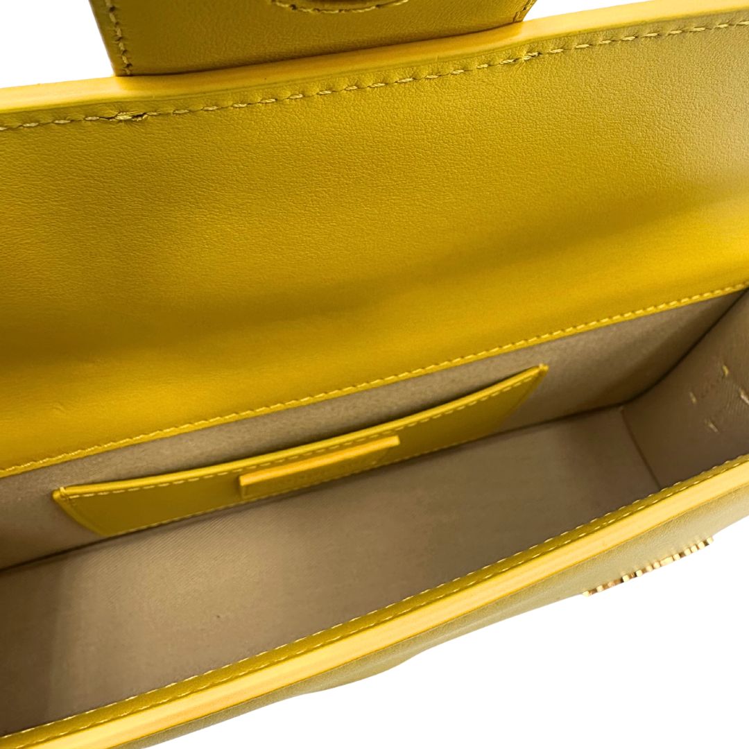 interno Borsa Jacquemus Le Bambino Long in pelle gialla con parti metalliche dorate; munita di un manico singolo. Completa di dustbag e cartellini, di lusso, originale, ottime condizioni.