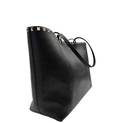 lato Borsa Valentino Garavani in pelle nera con parti metalliche dorate, impreziosita da borchie piramidali sulle finiture superiori; munita di doppi manici, di lusso, originale, ottimo stato. 