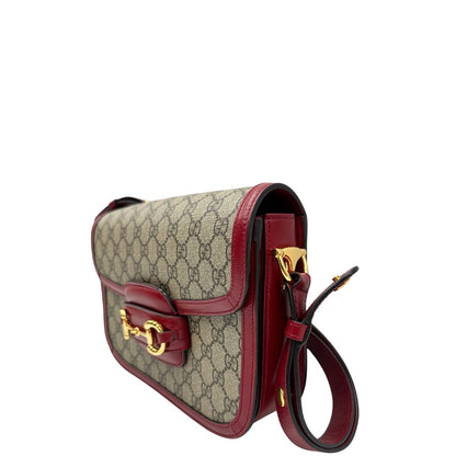 lato Borsa Gucci Horsebit 1955 in canvas beige GG con finiture in pelle bordeaux e parti metalliche dorate. Munita di un manico leggermente allungabile e rifinita con iconico morsetto Horsebit sulla chiusura. Completa di dustbag, di lusso, originale, ottime condizioni, usata. 