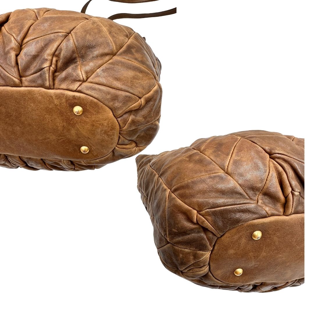 angoli Borsa Miu Miu in pelle color cammello con parti metalliche dorate; munita di un manico singolo e una tracolla amovibile, di lusso, usata, originale, ottime condizioni. 