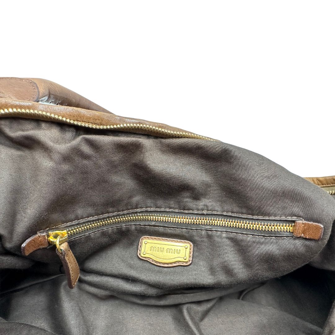 interni Borsa Miu Miu in pelle color cammello con parti metalliche dorate; munita di un manico singolo e una tracolla amovibile, di lusso, usata, originale, ottime condizioni. 