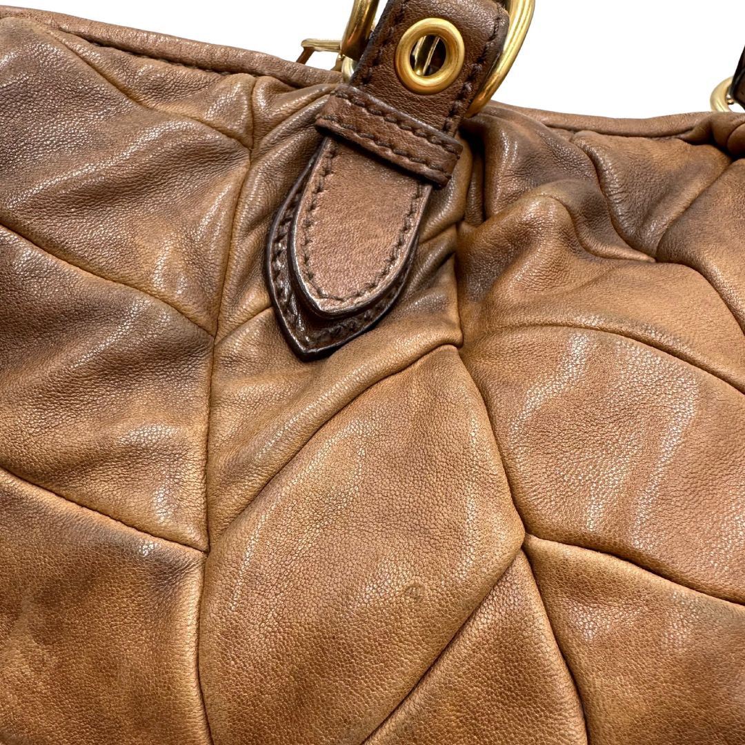 dettaglio Borsa Miu Miu in pelle color cammello con parti metalliche dorate; munita di un manico singolo e una tracolla amovibile, di lusso, usata, originale, ottime condizioni. 