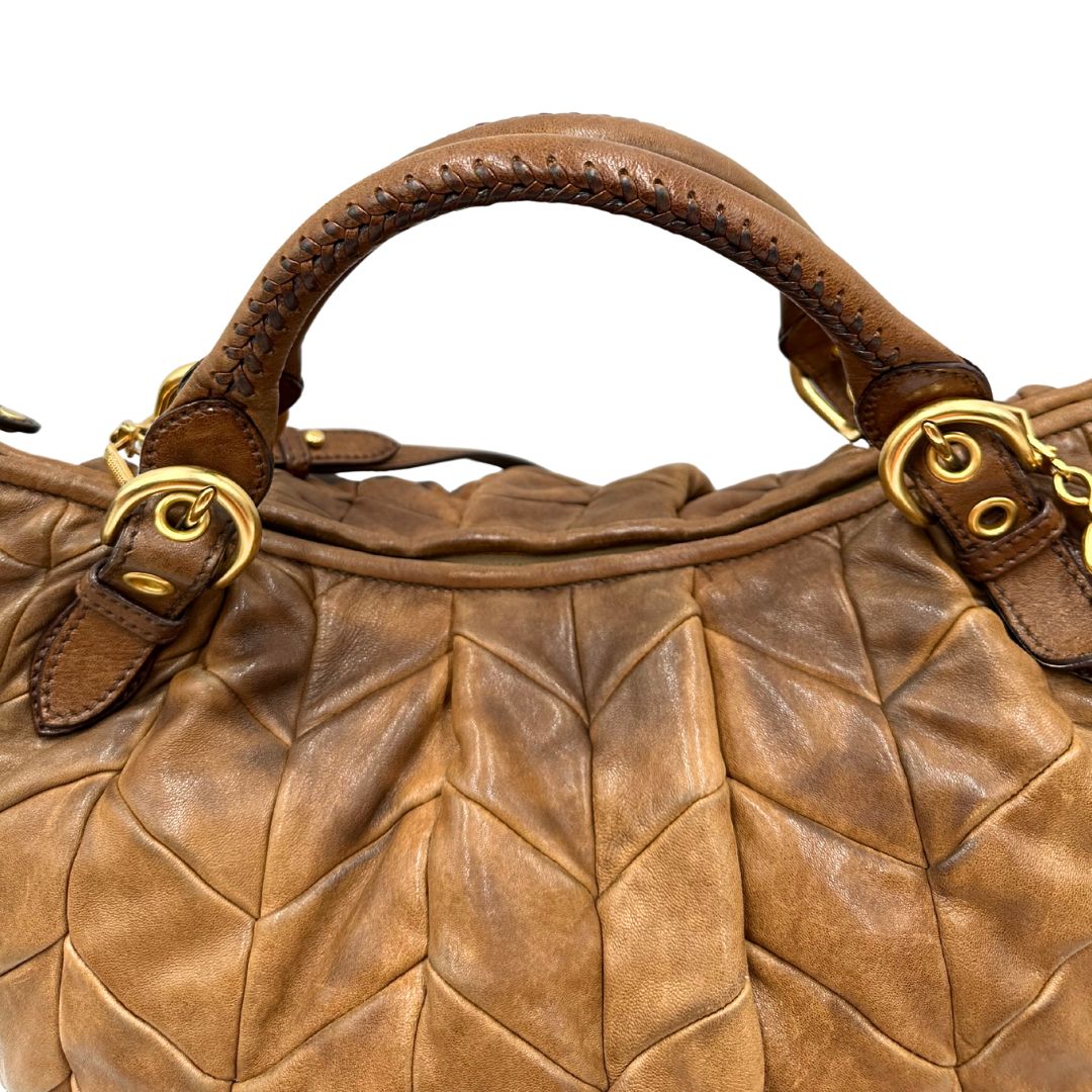 manici Borsa Miu Miu in pelle color cammello con parti metalliche dorate; munita di un manico singolo e una tracolla amovibile, di lusso, usata, originale, ottime condizioni. 