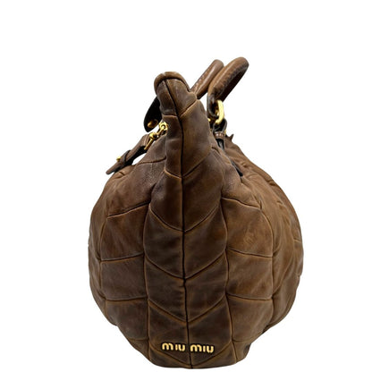 lato Borsa Miu Miu in pelle color cammello con parti metalliche dorate; munita di un manico singolo e una tracolla amovibile, di lusso, usata, originale, ottime condizioni. 