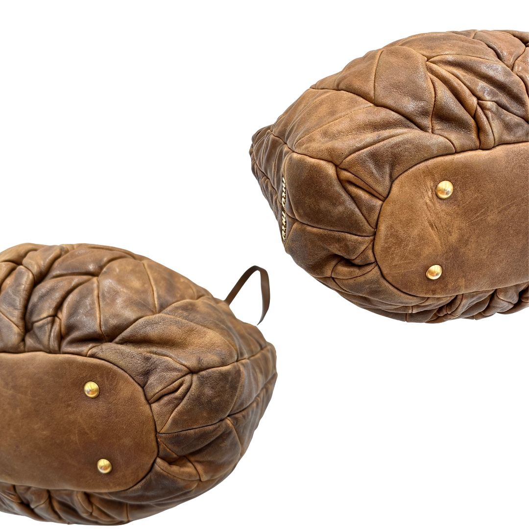 angoli Borsa Miu Miu in pelle color cammello con parti metalliche dorate; munita di un manico singolo e una tracolla amovibile, di lusso, usata, originale, ottime condizioni. 