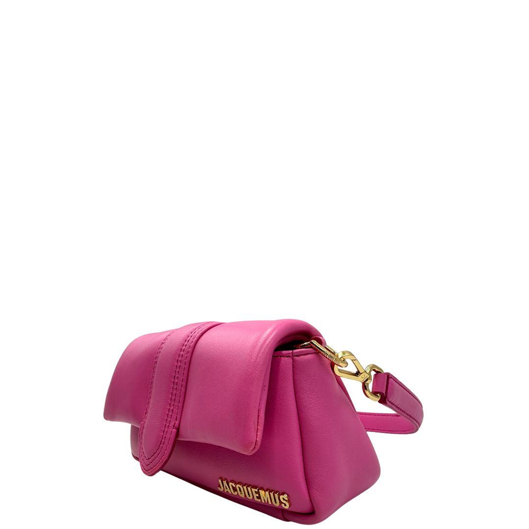 lato Borsa Jacquemus in pelle color neon pink con parti metalliche dorate; munita di un manico singolo e una tracolla, entrambe amovibili. Completa di dustbag, di lusso, originale, ottime condizioni. 