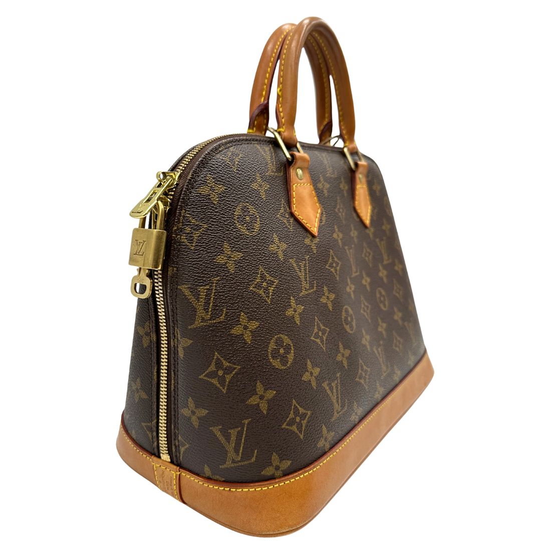 lato Borsa Louis Vuitton in canvas marrone monogram con finiture in vacchetta naturale e parti metalliche dorate; munita di doppi manici stondati, da portare a mano. Completa di chiavi e lucchetto, di lusso, originale, ottime condizioni.