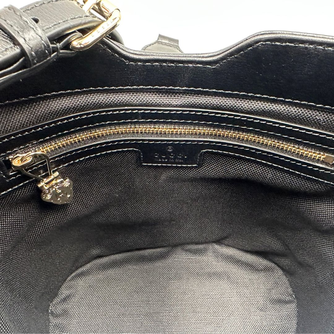 interno Mini bucket Gucci in pelle nera con parti metalliche dorate; munito di una tracolla in tessuto Web verde e rossa. Completo di dustbag, di lusso, eccellenti condizioni, originale, usato. 