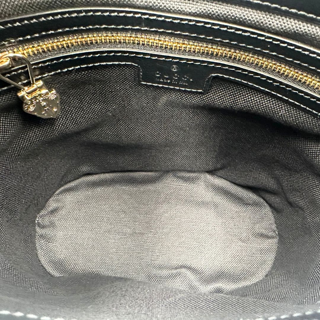 interno Mini bucket Gucci in pelle nera con parti metalliche dorate; munito di una tracolla in tessuto Web verde e rossa. Completo di dustbag, di lusso, eccellenti condizioni, originale, usato. 