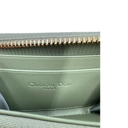 Portafoglio Dior in pelle verde trama cannage con parti metalliche dorate; munita di charm amovibile. Completo di corredo, di lusso, originale, ottime condizioni.