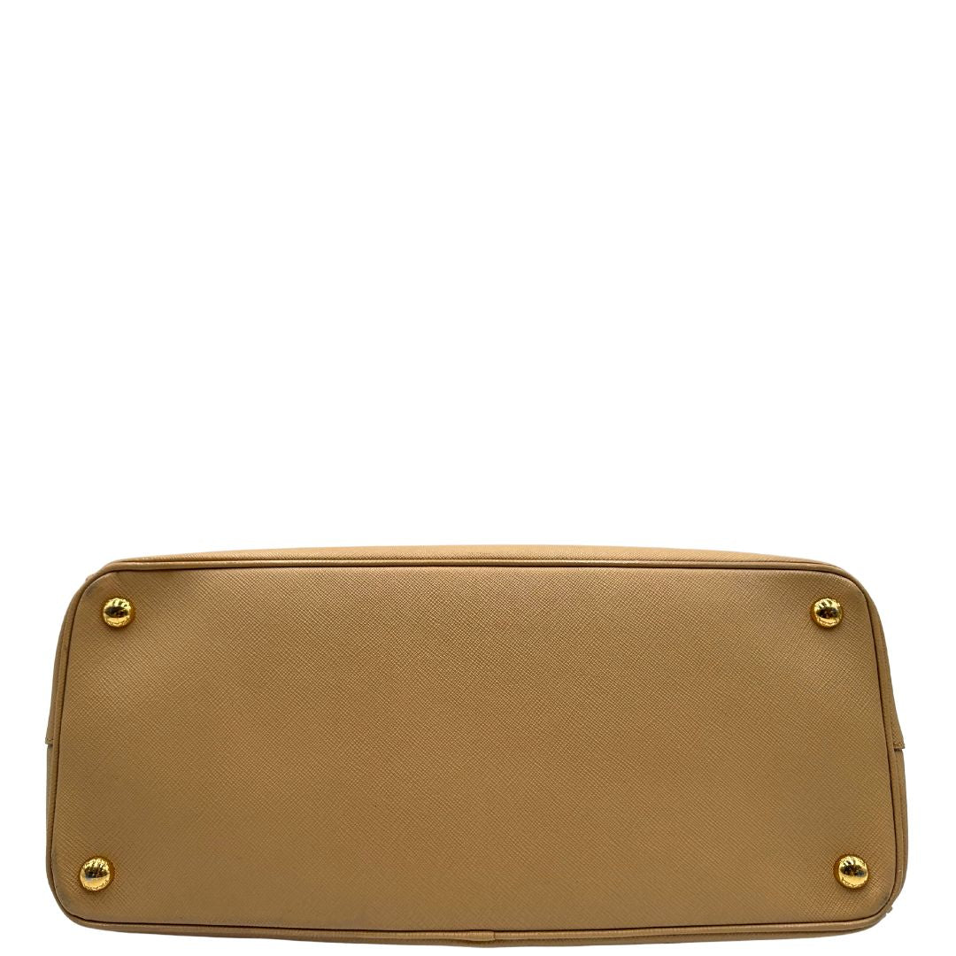 base  Borsa Prada in pelle saffiano color nocciola con parti metalliche dorate; munita di doppi manici stondati e impreziosita da una clochette portachiavi. Completa di dustbag, di lusso, originale, buone condizioni. 