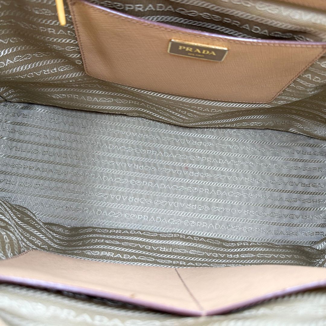 interno  Borsa Prada in pelle saffiano color nocciola con parti metalliche dorate; munita di doppi manici stondati e impreziosita da una clochette portachiavi. Completa di dustbag, di lusso, originale, buone condizioni. 