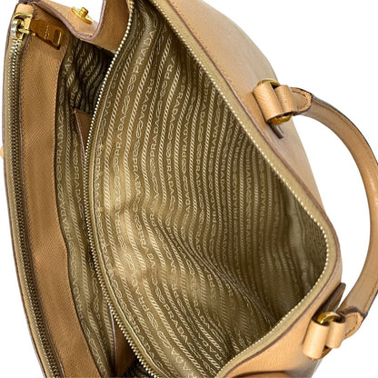 interno  Borsa Prada in pelle saffiano color nocciola con parti metalliche dorate; munita di doppi manici stondati e impreziosita da una clochette portachiavi. Completa di dustbag, di lusso, originale, buone condizioni. 