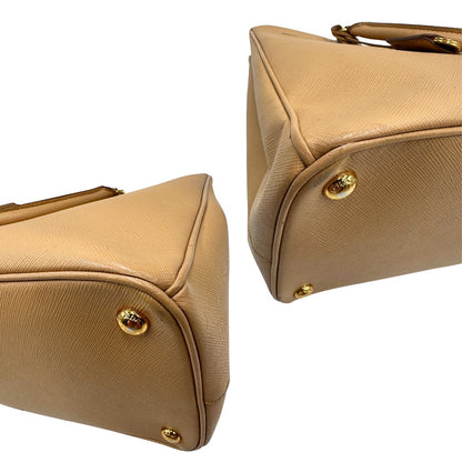 angoli  Borsa Prada in pelle saffiano color nocciola con parti metalliche dorate; munita di doppi manici stondati e impreziosita da una clochette portachiavi. Completa di dustbag, di lusso, originale, buone condizioni. 