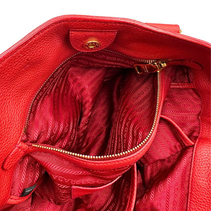 interno Borsa Tote Prada in pelle rossa con parti metalliche dorate; munita di doppi manici e una tracolla amovibile e regolabile, di lusso, originale, ottime condizioni, usata. 