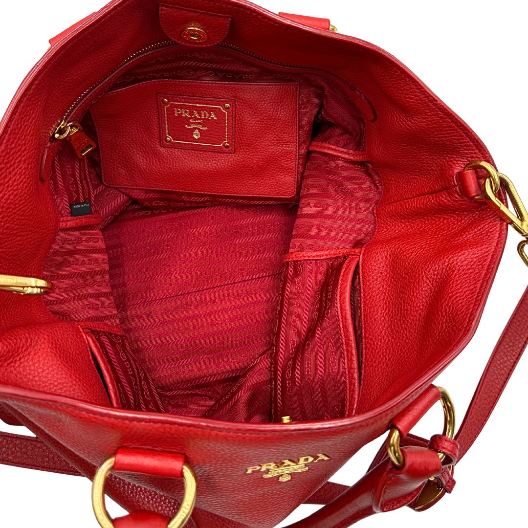 interno Borsa Tote Prada in pelle rossa con parti metalliche dorate; munita di doppi manici e una tracolla amovibile e regolabile, di lusso, originale, ottime condizioni, usata. 