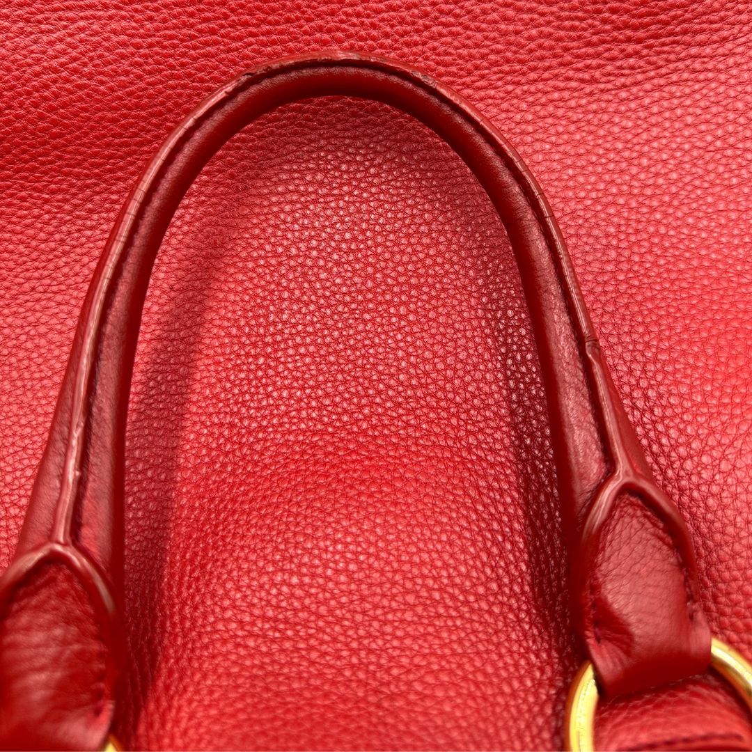 interno Borsa Tote Prada in pelle rossa con parti metalliche dorate; munita di doppi manici e una tracolla amovibile e regolabile, di lusso, originale, ottime condizioni, usata. 