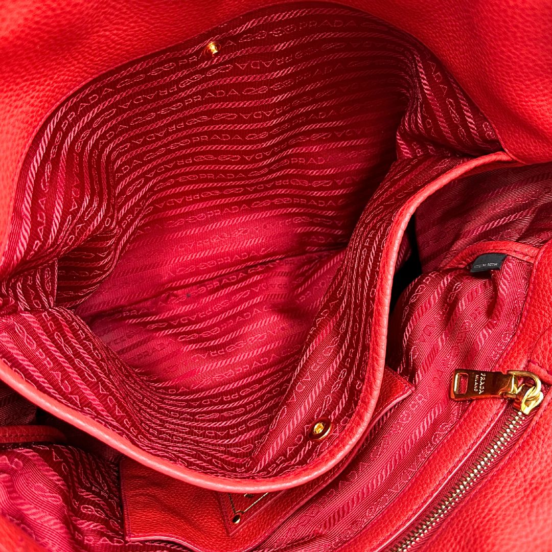 interno Borsa Tote Prada in pelle rossa con parti metalliche dorate; munita di doppi manici e una tracolla amovibile e regolabile, di lusso, originale, ottime condizioni, usata. 