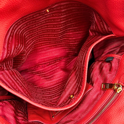interno Borsa Tote Prada in pelle rossa con parti metalliche dorate; munita di doppi manici e una tracolla amovibile e regolabile, di lusso, originale, ottime condizioni, usata. 