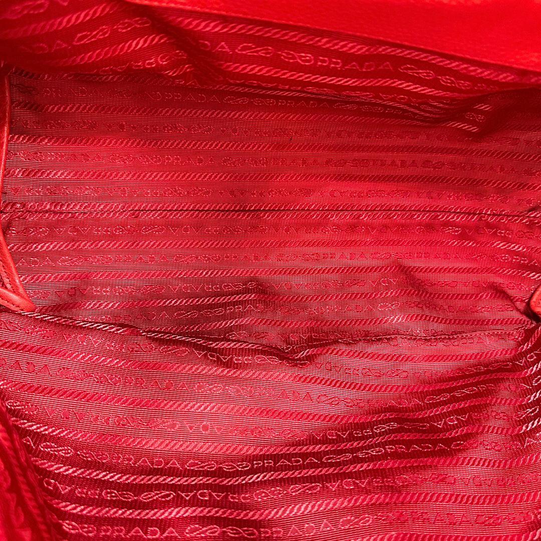 interno Borsa Tote Prada in pelle rossa con parti metalliche dorate; munita di doppi manici e una tracolla amovibile e regolabile, di lusso, originale, ottime condizioni, usata. 