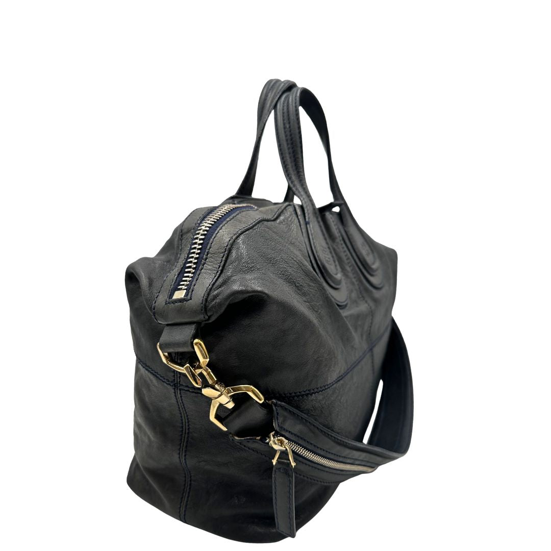 Laterali di una Borsa Givenchy Nightingale in pelle blu notte e parti metalliche dorate. Munita di doppi manici e tracolla una amovibile arricchita da una cerniera decorativa. Indossabile a mano o a tracolla. Originale, usata, di lusso, in ottime condizioni