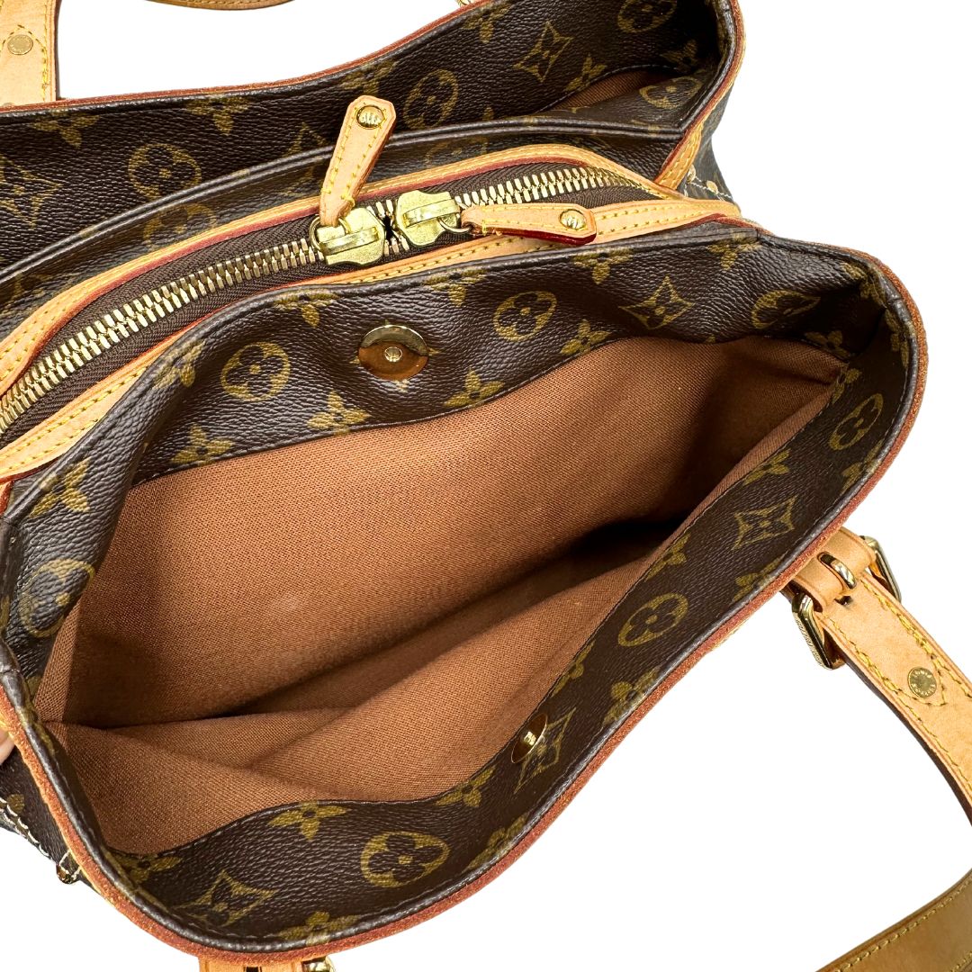 Interno di una borsa Louis Vuitton in canvas marrone monogram con cuciture decorative e finiture in vacchetta naturale. Parti metalliche dorate; munita di doppi manici, indossabile a spalla.