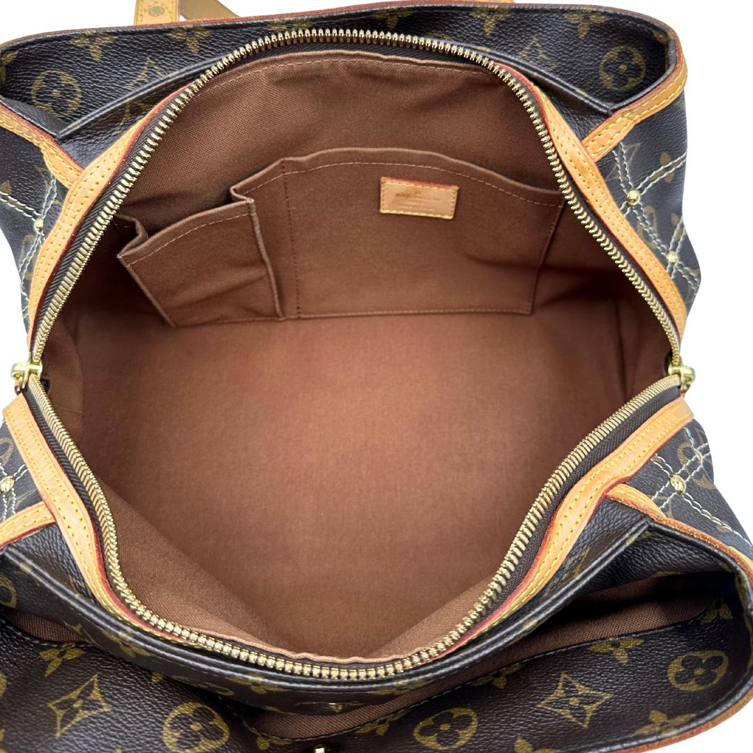 Interno di una borsa Louis Vuitton in canvas marrone monogram con cuciture decorative e finiture in vacchetta naturale. Parti metalliche dorate; munita di doppi manici, indossabile a spalla.